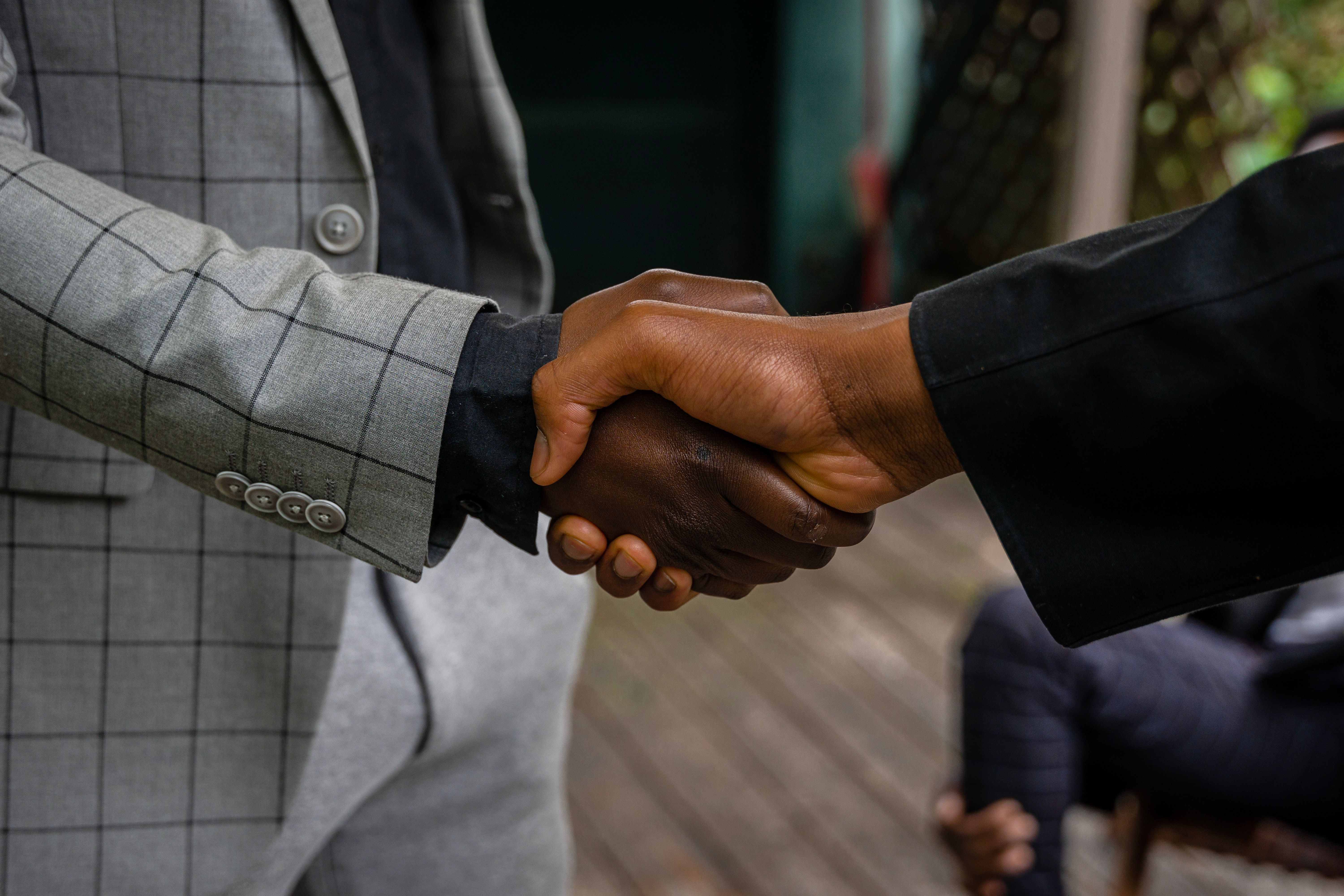 Two people in business attire shaking hands.